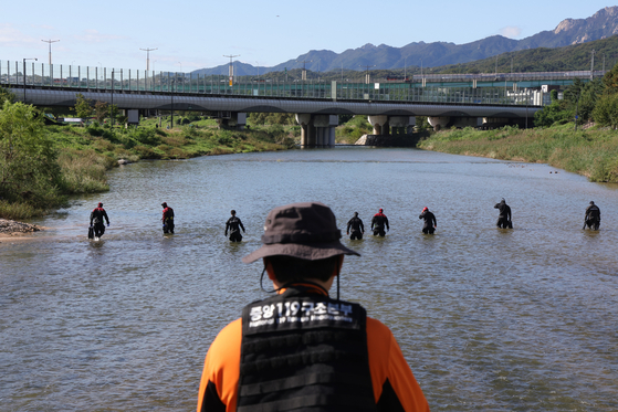 Rescue workers search for a missing person in Jungnang Stream in Howon-dong, Uijeongbu, Gyeonggi on Oct. 16. [YONHAP]