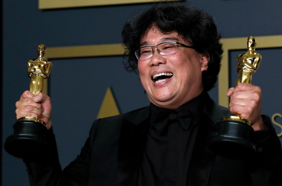 Bong Joon Ho poses with two Oscars, one for Best Director and one for Best International Feature Film for ″Parasite″ (2019) in the photo room during the 92nd Academy Awards in Hollywood, Los Angeles, on February 9, 2020. [REUTERS/YONHAP]