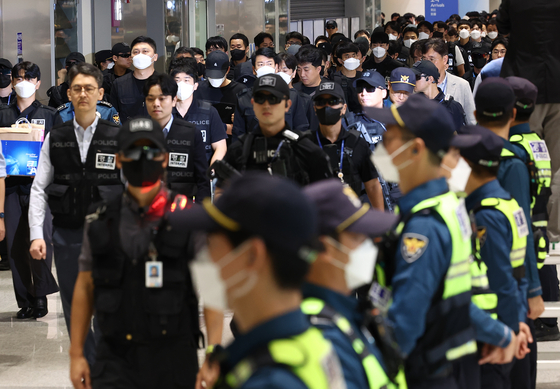 Korean nationals who were detained in Cambodia over their alleged involvement in online scams arrive at Incheon International Airport on Oct. 18. [YONHAP]