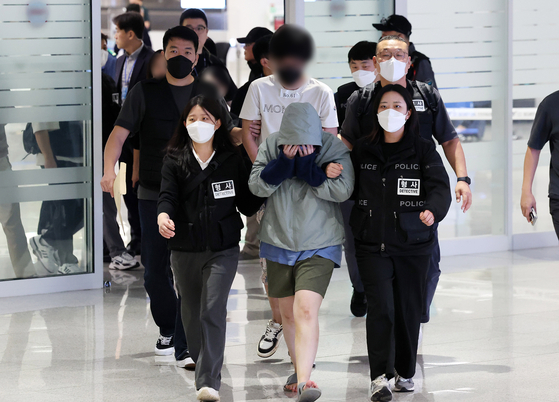 A total of 64 Korean nationals who were detained in Cambodia over their alleged involvement in online scams arrive at Incheon International Airport on Oct. 18 after Cambodia decided to repatriate them. [YONHAP]