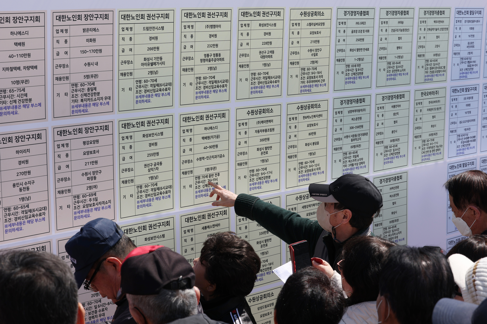 Job seekers aged 60 and older look at a job posting board during the 17th Senior Job Fair held at Hwaseong Haenggung Square in Paldal District, Suwon, Gyeonggi, on March 28. [NEWS1] 