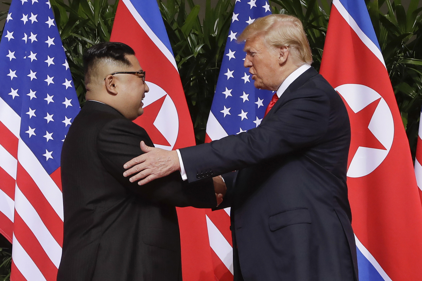 U.S. President Donald Trump, right, shakes hands with North Korea leader Kim Jong-un at the Capella resort on Sentosa Island in Singapore on June 12, 2018. [AP/YONHAP] 