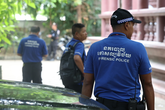 Cambodian police officials are seen at a temple in Phnom Penh on Oct. 20, where an autopsy of a Korean student allegedly tortured to death in the country was scheduled to take place. [YONHAP]