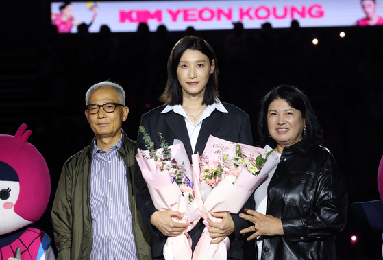 Kim Yeon-koung, center, poses for photos with her parents at her retirement ceremony at Incheon Samsan World Gymnasium in Incheon on Oct. 18. [NEWS1]