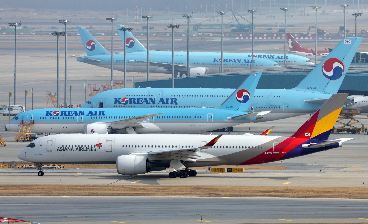 An Asiana Airlines plane passes in front of a Korean Air aircraft on the runway at Incheon International Airport on Feb. 13, 2024. [NEWS1]
