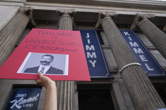 A demonstrator holds a sign outside El Capitan Entertainment Centre, where the late-night show ″Jimmy Kimmel Live!″ is staged on Sept. 18, in Los Angeles. [AP/YONHAP]