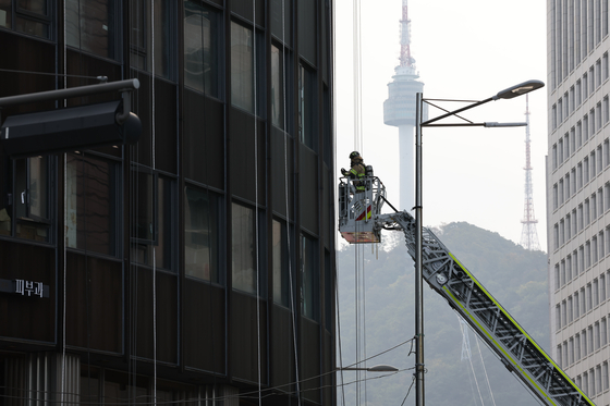 Firefighters work to extinguish a blaze at the Seoul Center Building in Jung District, central Seoul on Oct. 21. [NEWS1]