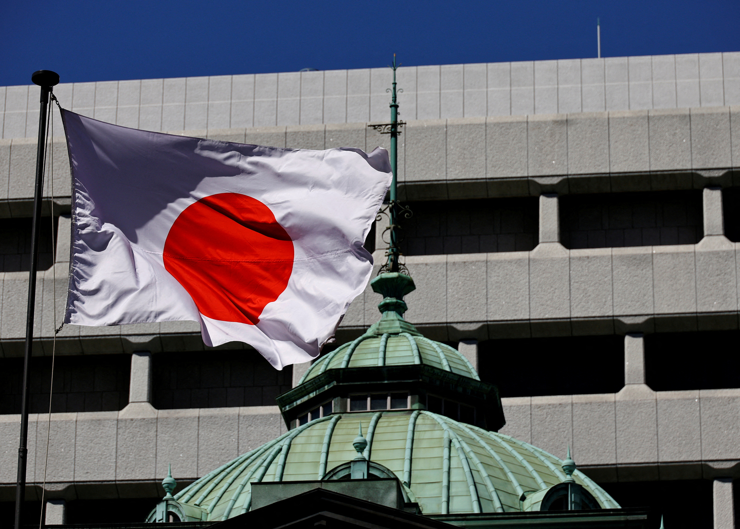 The Japanese national flag waves at the Bank of Japan building in Tokyo on March 18, 2024. [REUTERS/YONHAP]
