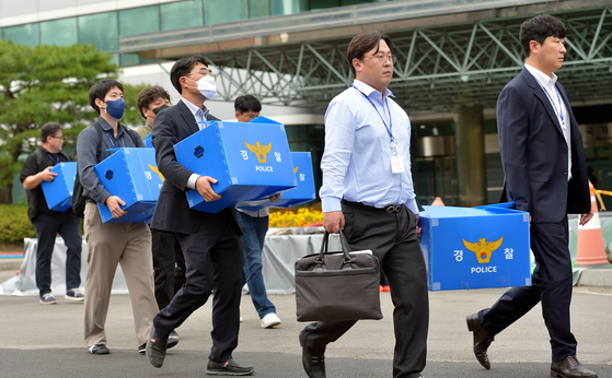 Investigators carry seized items after a raid at the National Information Resources Service on Oct. 2. [NEWS1]