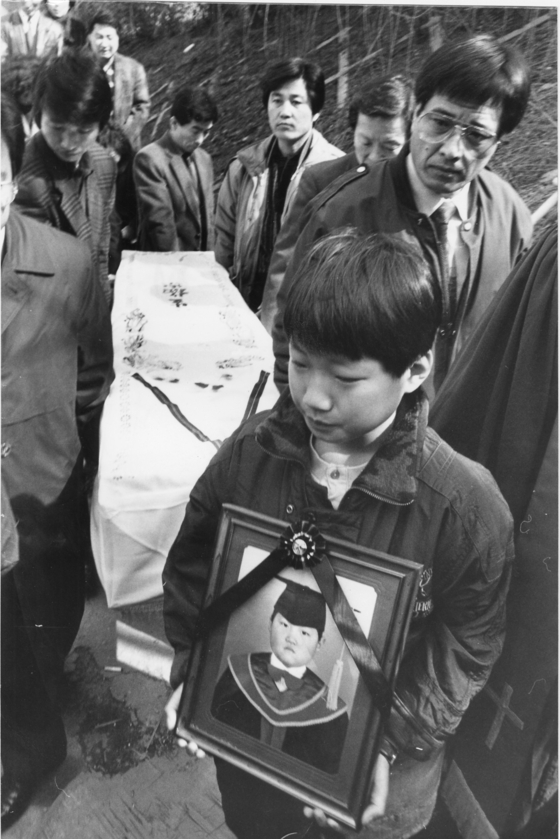 The older brother of Lee Hyung-ho cries as he carries his portrait during his funeral procession on March 15, 1991. [JOONGANG ILBO]