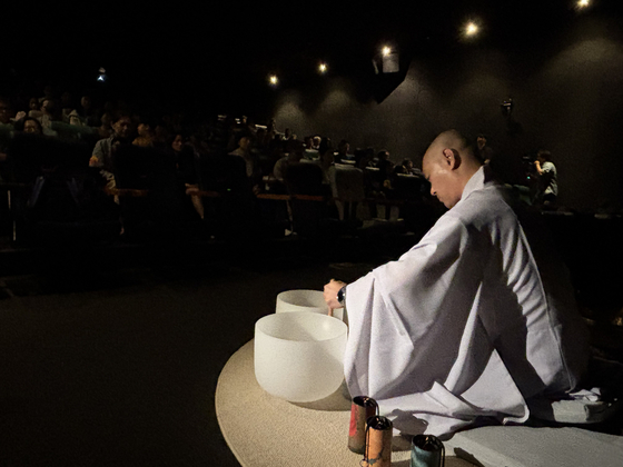 Buddhist monk Il Hwa leads a music meditation with crystal singing bowls at CGV Dongdaemun in Jung District, central Seoul, on Oct.18. [LEE JIAN]