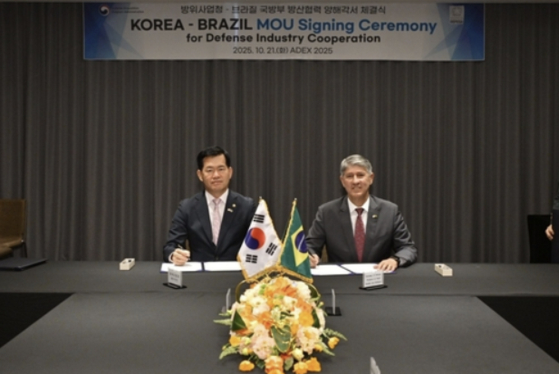 Seok Jong-gun, left, the minister of Defense Acquisition Program Administration (DAPA), signs an agreement with Brazil's Heraldo Luiz Rodrigues, secretary of defense products, ministry of defense, in Seoul on Oct. 22. [YONHAP]
