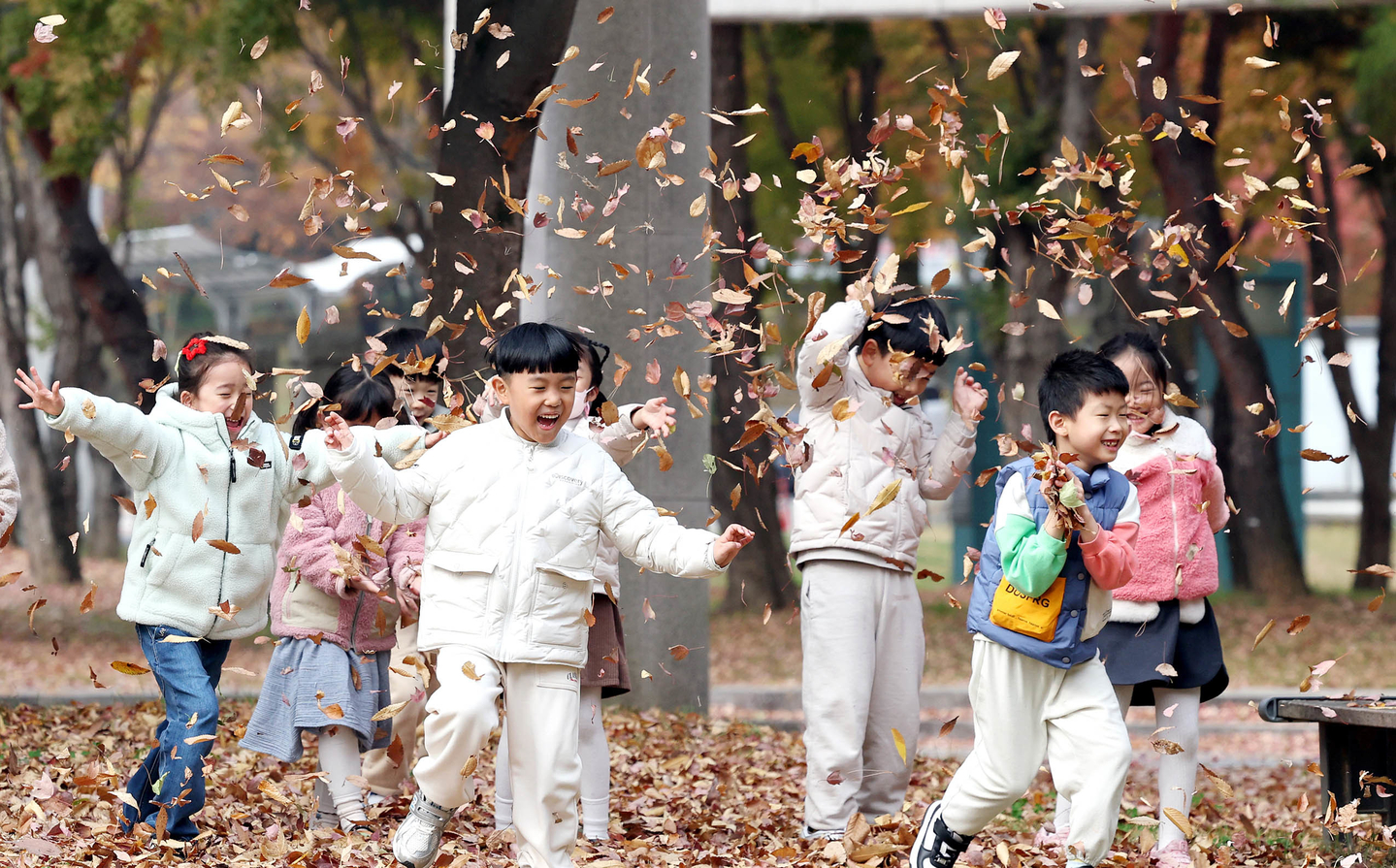 Children play among autumn leaves at a park in Buk District, Gwangju, on Nov. 21, 2024. [GWANGJU'S BUK DISTRICT OFFICE]