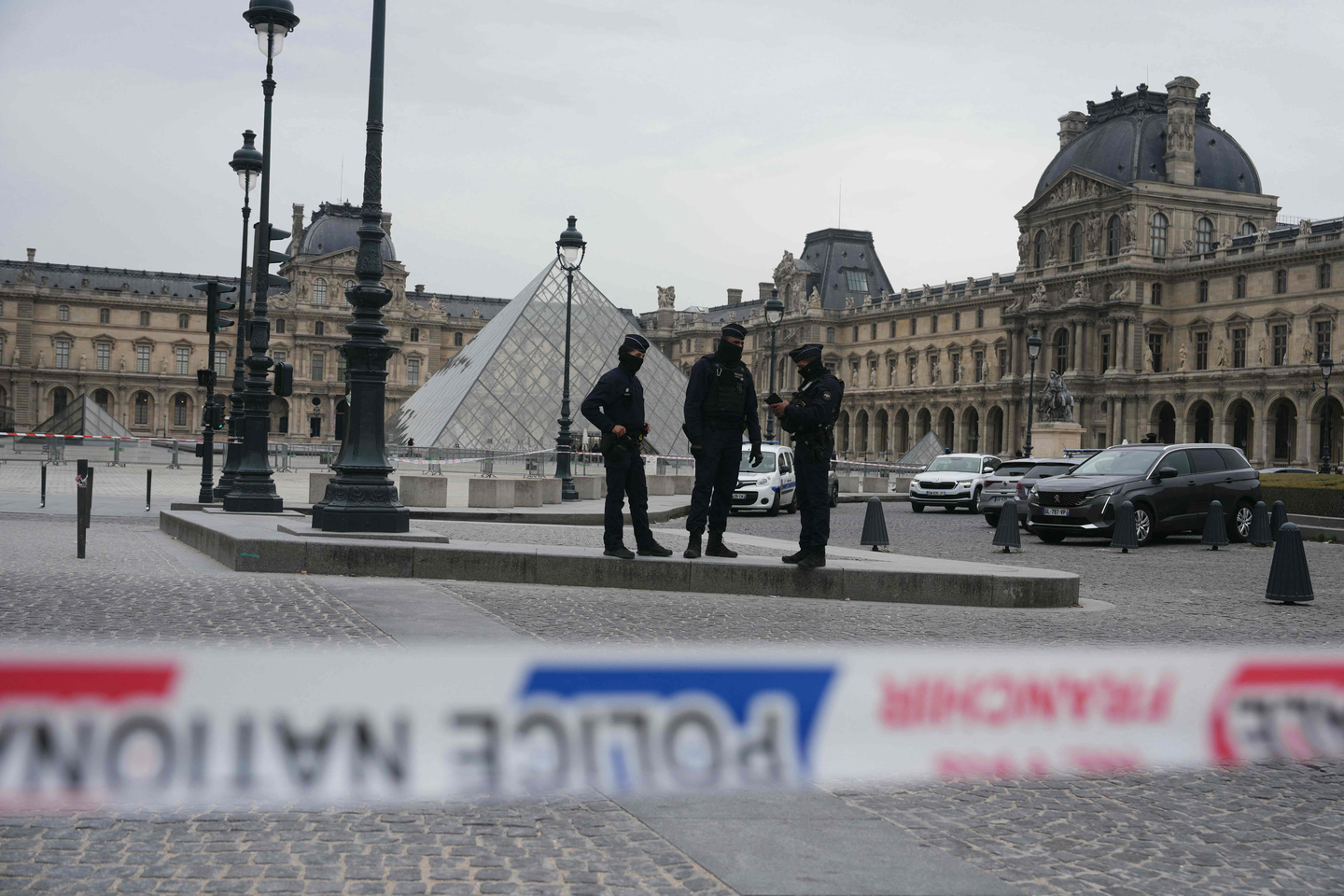 French police officers patrol in front of the Louvre Museum after it was robbed, with the Louvre Pyramid designed by Ieoh Ming Pei in the background, in Paris on Oct. 19. [AFP/YONHAP]