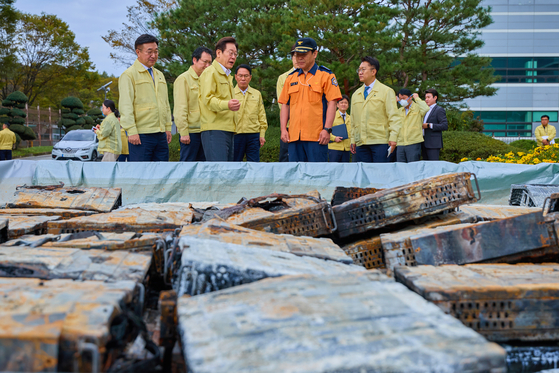 President Lee Jae Myung examines batteries moved outside for fire suppression at the National Information Resources Service's Daejeon headquarters in Yuseong District, Daejeon, on Oct. 10. [YONHAP]