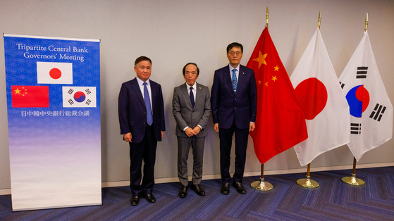 Bank of Korea Gov. Rhee Chang-yong, right, poses for a photo with Bank of Japan Gov. Kazuo Ueda, center, and People's Bank of China (PBOC) Gov. Pan Gongsheng, left, ahead of their meeting held in Washington on Oct. 15. [YONHAP]