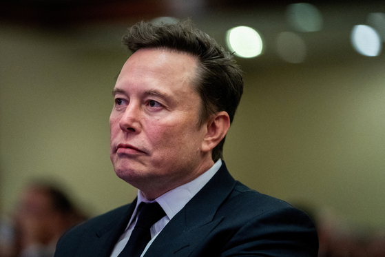 Tesla CEO and X owner Elon Musk listens as U.S. President Donald Trump speaks during a meeting with House Republicans at the Hyatt Regency hotel in Washington on Nov. 13, 2024. [REUTERS/YONHAP] 