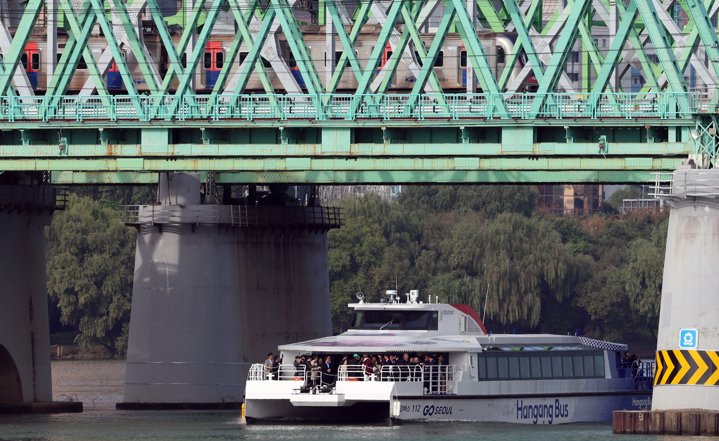 A Hangang Bus passes the Han River Railway Bridge near Nodeul Island in Yongsan District, central Seoul, on Oct. 21. [NEWS1]