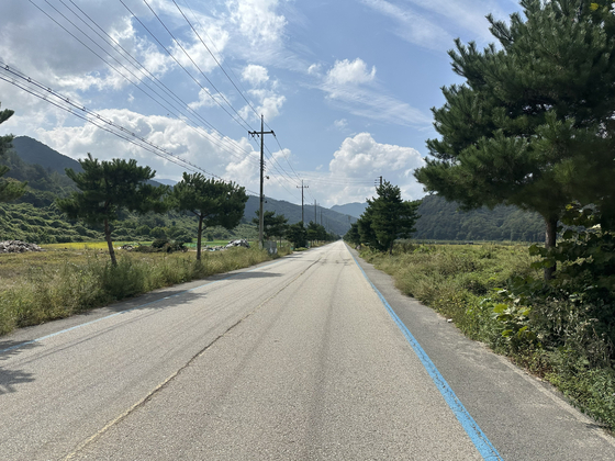 The road out of Chungju passes through some farmland before beginning the climb to Suanbo, North Chungcheong, on Sept. 29. [JIM BULLEY]