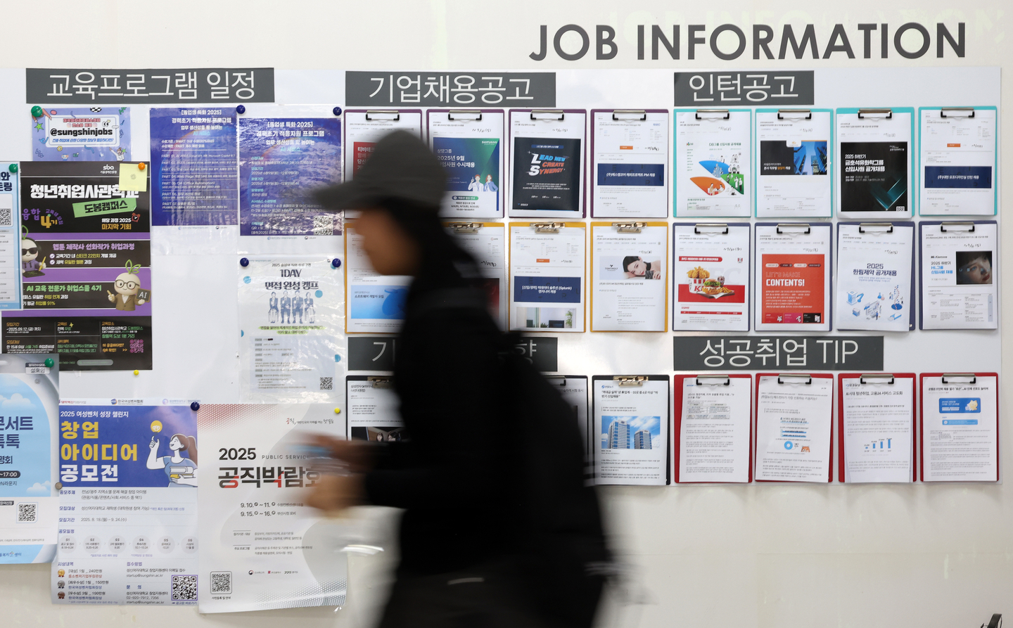 Students walk past a job board at a university in Seoul on Sept. 10. [YONHAP]