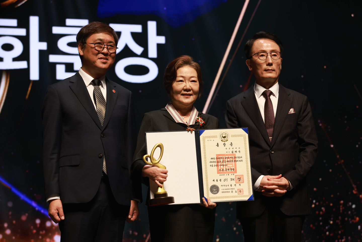 Actor Kim Hae-sook, center, poses for photos after receiving the Eungwan, or silver crown, Order of Cultural Merit during the Korea Popular Culture and Arts Awards at the National Theater's Haeoreum Grand Theater in Jung District, central Seoul on Oct. 23. [KOREA CREATIVE CONTENT AGENCY]