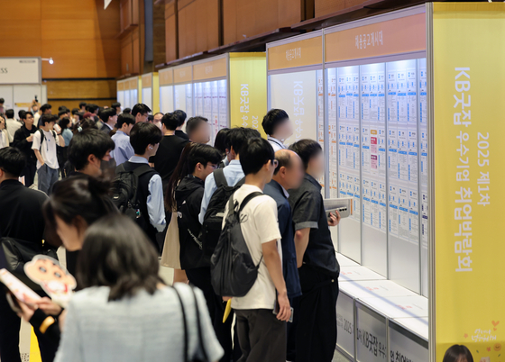 Job seekers read notices on openings at a job fair held at Coex in Gangnam District, southern Seoul on May 26. [NEWS1] 