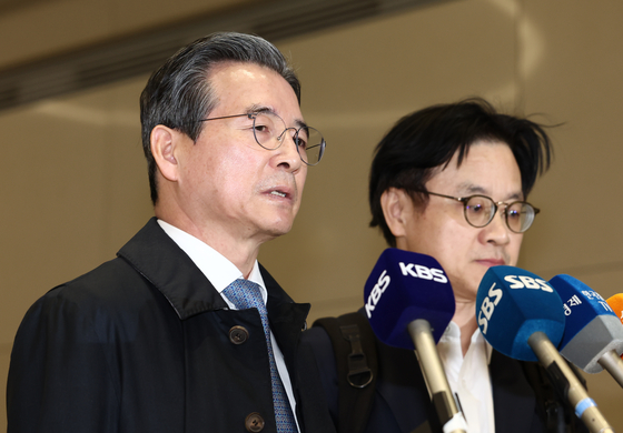 Presidential Director of National Policy Kim Yong-beom, left, and Industry Minister Kim Jung-kwan, right, speak to reporters upon returning from the United States at Incheon International Airport on Oct. 24. [NEWS1]
