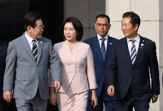 President Lee Jae Myung, left, heads toward the presidential jet at Seoul Air Base in Seongnam on Oct. 26 while speaking with liberal Democratic Party Chairman Rep. Jung Chung-rae, right, before departing for Malaysia to attend the Asean Summit. [YONHAP] 