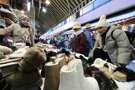 A vendor sells winter gear at Namdaemun Market in central Seoul on Oct. 27, as morning temperatures dropped to 4 degrees Celsius, bringing an early taste of winter. [YONHAP]