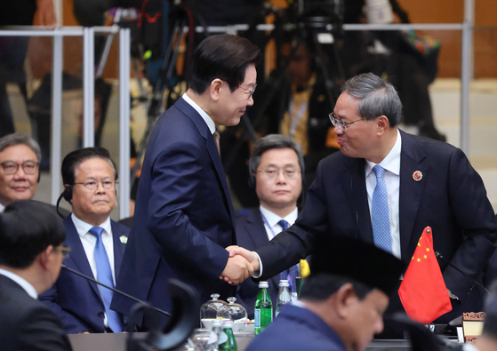 President Lee Jae Myung, left, shakes hands with Chinese Premier Li Qiang during the Asean-plus-three summit, involving South Korea, China and Japan, in Kuala Lumpur, Malaysia, on Oct. 27. [JOINT PRESS CORPS]