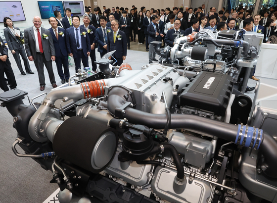 Visitors look at models of various ships on display at the Hanwha Ocean booth during a shipbuilding exhibition at BEXCO Exhibition Center in Busan on Oct. 21. [SONG BONG-GEUN]