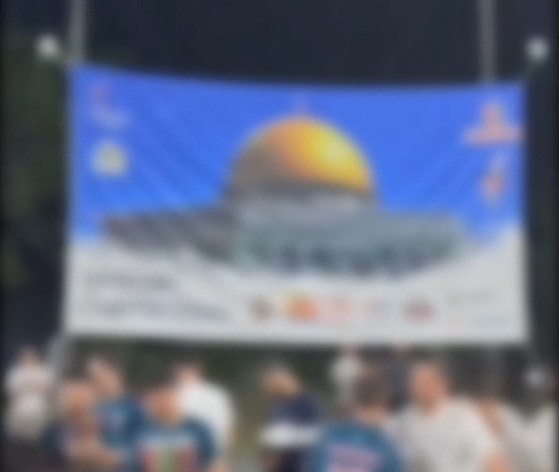 A blurred photo of an Uzbek national, who was apprehended by police for allegedly spreading Islamist extremism on social media and funding terrorist organizations, posing with members from a local football club. [GYEONGGI NAMBU PROVINCIAL POLICE AGENCY]