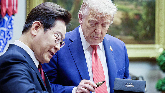 President Lee Jae Myung, left, presents U.S. President Donald Trump with a fountain pen he used to sign the guestbook during the Korea-U.S. summit held at the White House in Washington on Aug. 25. [JOINT PRESS CORPS]