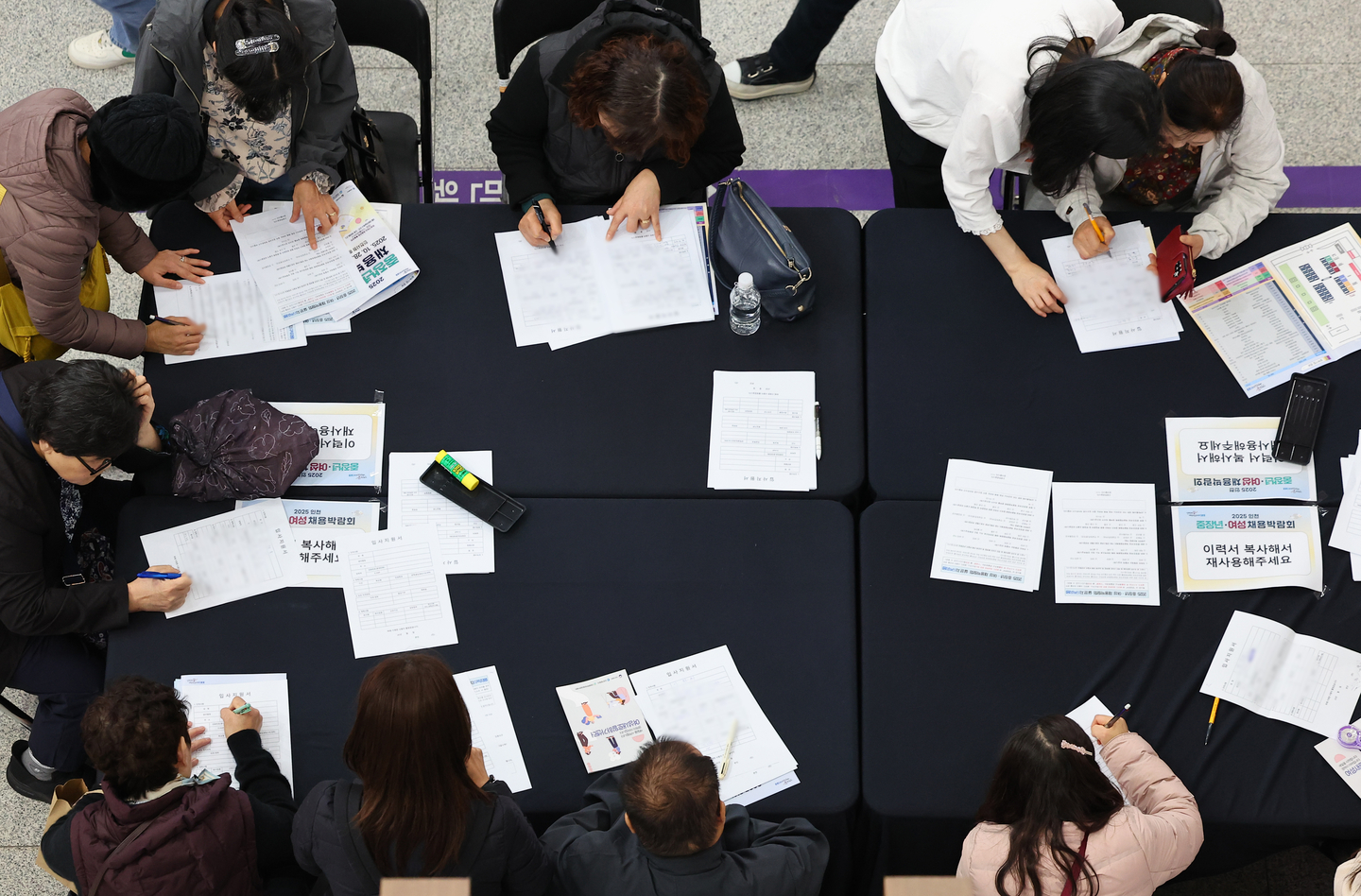 Job seekers fill out resumes at a job fair for middle-aged workers and women at Incheon City Hall in Namdong District, Incheon on Oct. 28. [YONHAP]