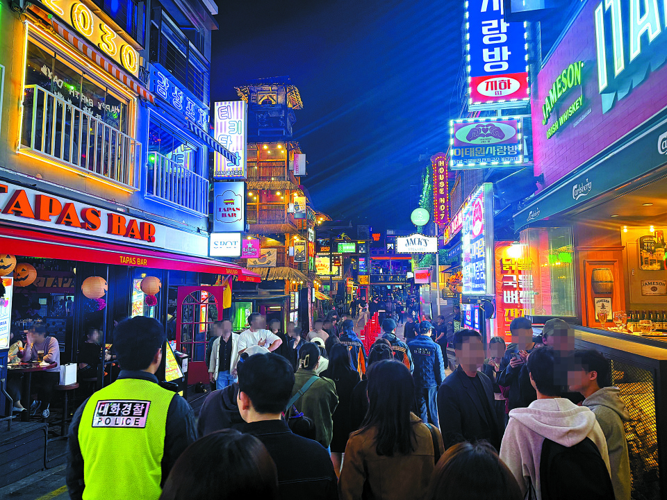Visitors fill the streets of Itaewon in Yongsan District, central Seoul, as police patrol and manage crowds ahead of the Halloween weekend on Oct. 25. [CHO JUNG-WOO]