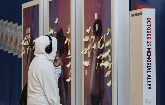 A visitor reads messages left by mourners at the October 29 Memorial Alley in Itaewon, Yongsan District, central Seoul, on Oct. 28. [JOONGANG ILBO]