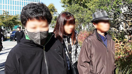 The father and daughter accused in the cyanide makgeolli case walk into Gwangju High Court in Gwangju on Oct. 28 for their retrial verdict hearing. [YONHAP] 