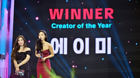 TikTok creator Amy, right, who won the Creator of the Year award at the second annual TikTok Awards in Korea, delivers an awards speech during the ceremony at Korea University’s Hwajeong Gymnasium in Seoul on Oct. 25. [TIKTOK KOREA]T