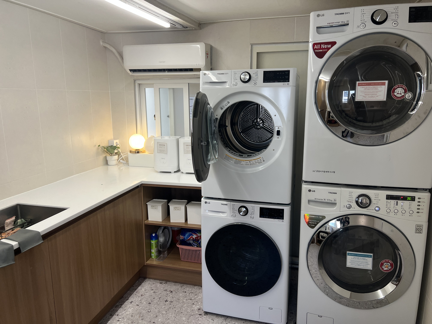 Laundry machines and dryers are at the shared laundry zone in the gosiwon (small, affordable single-room housing) building where Lydia Rouka lives. [LYDIA ROUKA]