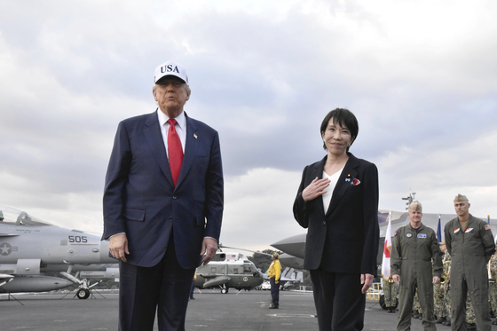 U.S. President Donald Trump and Japanese Prime Minister Sanae Takaichi are welcomed by U.S. military personnel upon their arrival on the USS George Washington docked at the Yokosuka Naval Base, south of Tokyo, Japan, on Oct. 28. [EPA/YONHAP] 