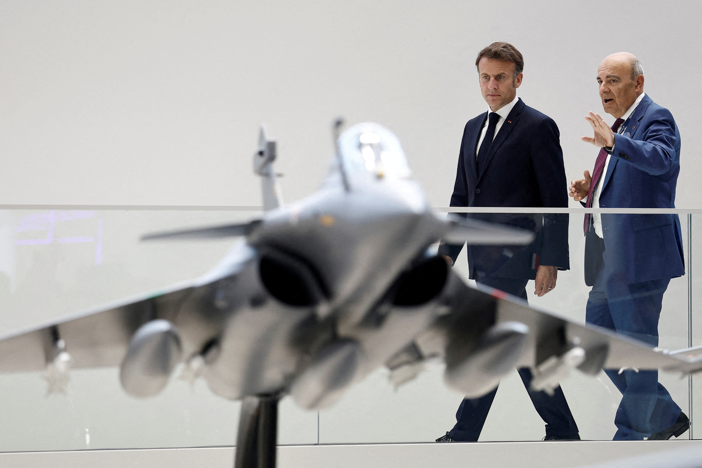French President Emmanuel Macron listens to Eric Trappier, Chairman and Chief Executive Officer of Dassault Aviation, as they look at a display model of a Rafale fighter jet at the stand of aircraft manufacturer Dassault Aviation during a visit at the 55th International Paris Airshow at Le Bourget Airport near Paris, France, June 20, 2025. [REUTERS/YONHAP]
