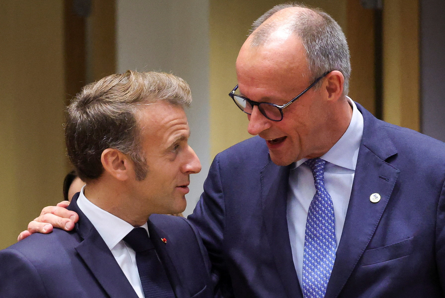 French President Emmanuel Macron and German Chancellor Friedrich Merz interact as they attend the European Union leaders' summit in Brussels, Belgium, October 23, 2025. [REUTERS/YONHAP]