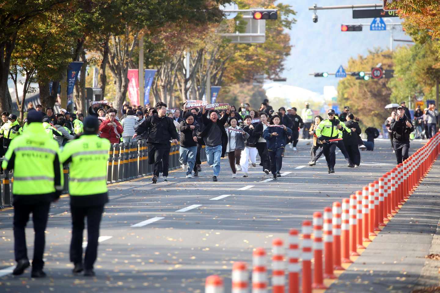 Protesters run toward the APEC summit venue, breaking a police cordon, near the National Gyeongju Museum in Gyeongju, on Oct. 29. [YONHAP]