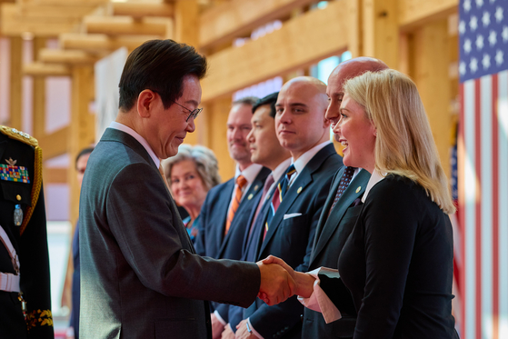 White House press secretary Karoline Leavitt, right, shakes hands with President Lee Jae Myung at the Korea-U.S. summit at the Gyeongju National Museum in Gyeongju, North Gyeongsang, on Oct. 29. [JOINT PRESS CORPS]