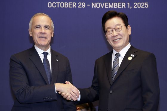 President Lee Jae Myung and Canadian Prime Minister Mark Carney shake hands upon meeting for a bilateral summit at a hotel in Gyeongju, North Gyeongsang, on Oct. 30. [JOINT PRESS CORPS]