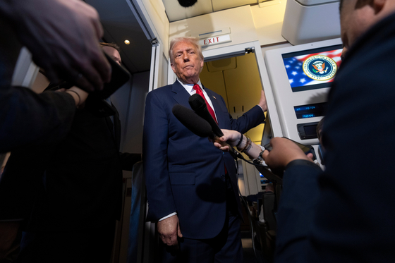 U.S. President Donald Trump speaks with reporters aboard Air Force One shortly after taking off from Busan on Oct. 30. [AP/YONHAP]