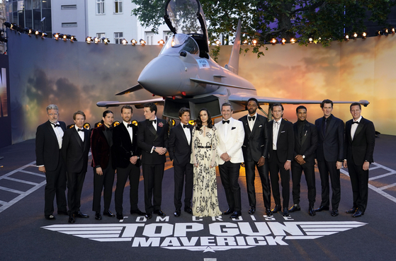 From left, producer Christopher McQuarrie, producer Jerry Bruckheimer, Danny Ramirez, Glen Powell, Miles Teller, Tom Cruise, Jennifer Connolly, Jon Hamm, Jay Ellis, Lewis Pullman, Greg Tarzan Davis, director Joseph Kosinski and producer David Ellison pose for the media during the 'Top Gun Maverick' UK premiere at a central London cinema, on May 19, 2022. [AP/YONHAP]