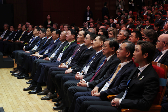 From seventh left, Shinsegae Group Chairman Chung Yong-jin, HD Hyundai Chairman Chung Ki-sun, Lotte Group Chairman Shin Dong-bin, Hyundai Motor Group Chairman Euisun Chung, Samsung Electronics Chairman Lee Jae-yong, LG Group Chairman Koo Kwang-mo and BTS member RM, right, listen to President Lee Jae Myung’s special address during the APEC CEO Summit at the Gyeongju Arts Center in North Gyeongsang on Oct. 29. [JOINT PRESS CORPS]
