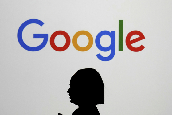 A woman walks by a giant screen with a logo at an event at the Paris Google Lab on the sidelines of the AI Action Summit in Paris, on Feb. 9. [AP/YONHAP]