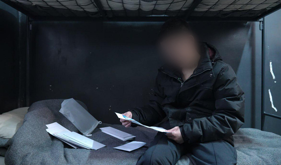 A North Korean prisoner of war meets with producer Kim Young-mi at a prisoner camp in Ukraine on Oct. 28 in this photo provided by an activist group on Oct. 30. [YONHAP]